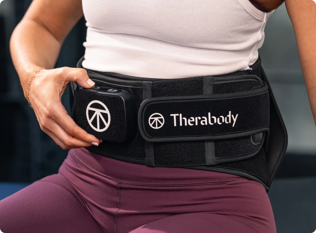 Woman adjusting the Therabody ThermBack LED compression straps